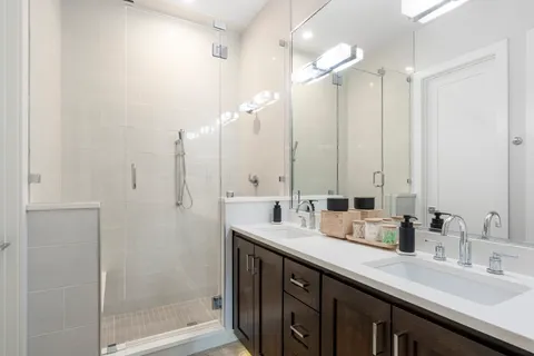 a bathroom with a double vanity sink mirror and shower