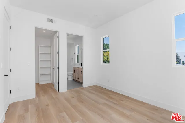 a view of empty room with wooden floor