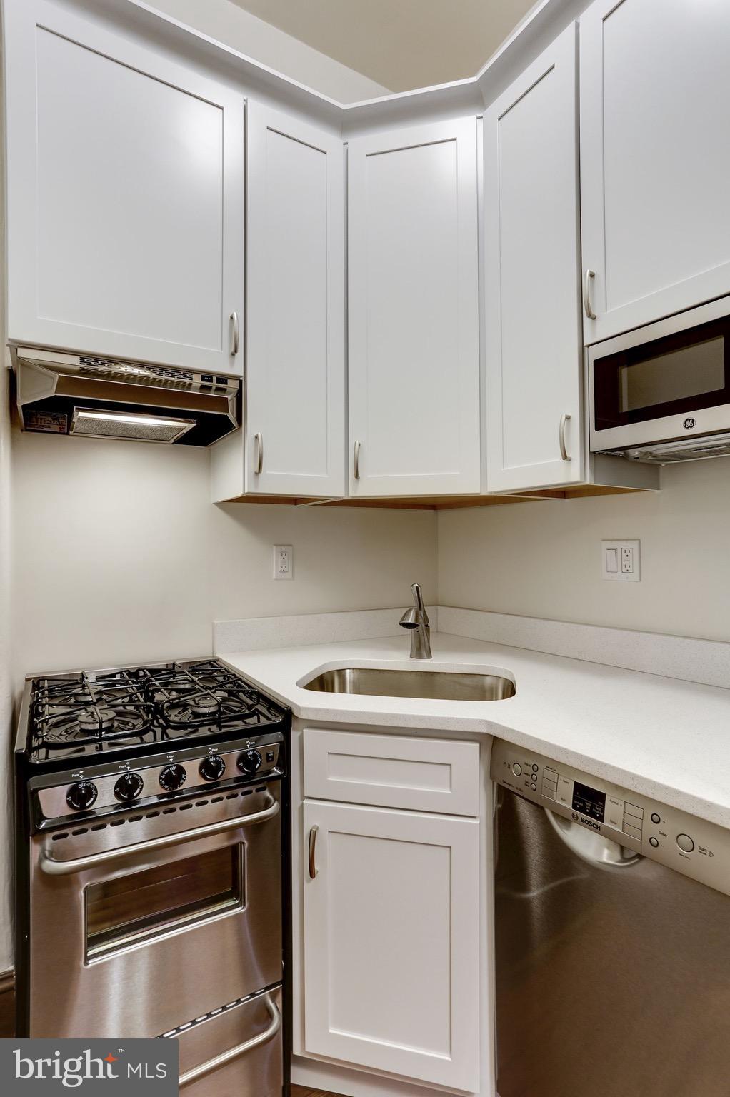 2220 20th Street Northwest, Unit 57 Washington, DC 20009 - Photo 12 of 27 a kitchen with appliances cabinets and a stove top oven