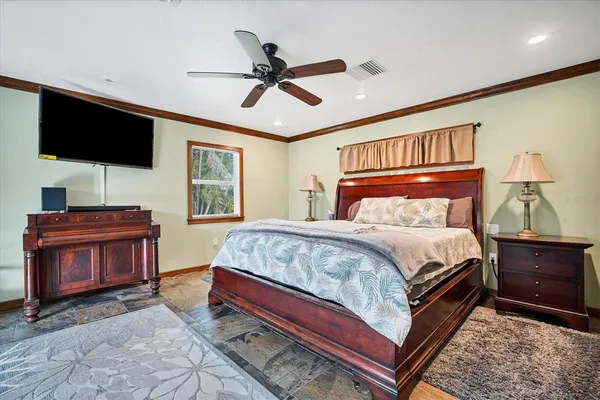 a bedroom with a bed bookshelf and a flat screen tv