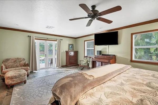 a bedroom with a bed window and a flat screen tv