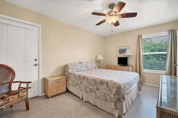 a bedroom with a bed a chandelier and a window