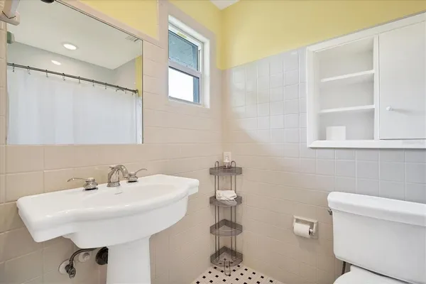 a bathroom with a sink a toilet and a mirror