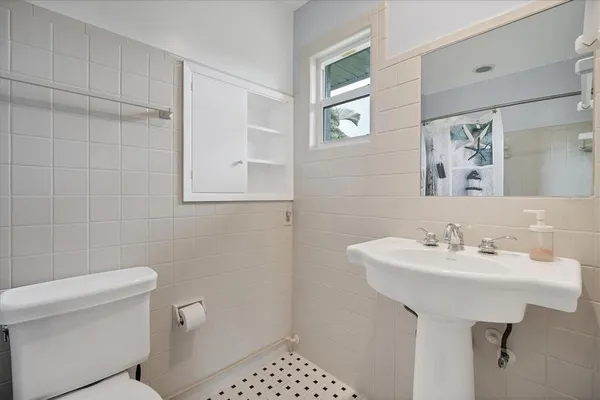 a bathroom with a sink a toilet and a mirror