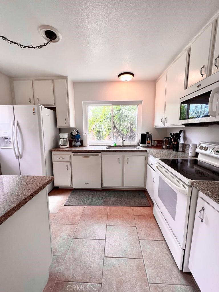 803 Caminito Azul Carlsbad, CA 92011 - Photo 7 of 44 a kitchen with a sink a stove top oven and cabinets
