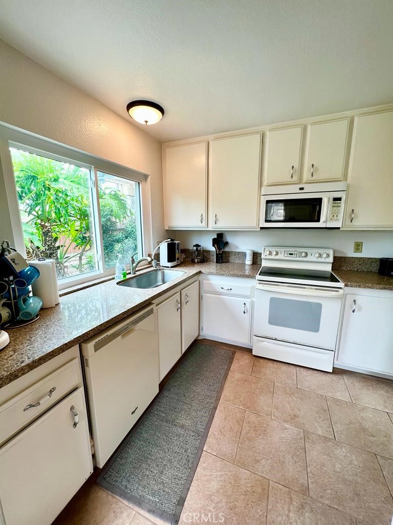 803 Caminito Azul Carlsbad, CA 92011 - Photo 9 of 44 a kitchen with a white stove top oven sink and cabinets
