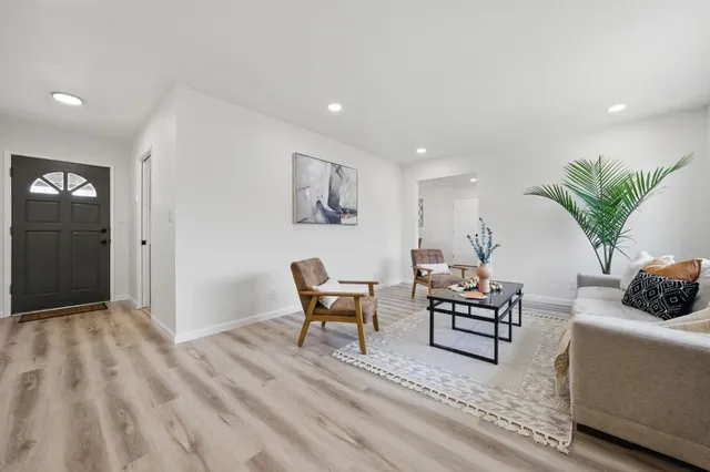 a living room with furniture and a wooden floor