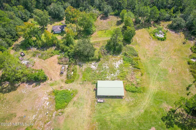 an aerial view of a residential houses with yard