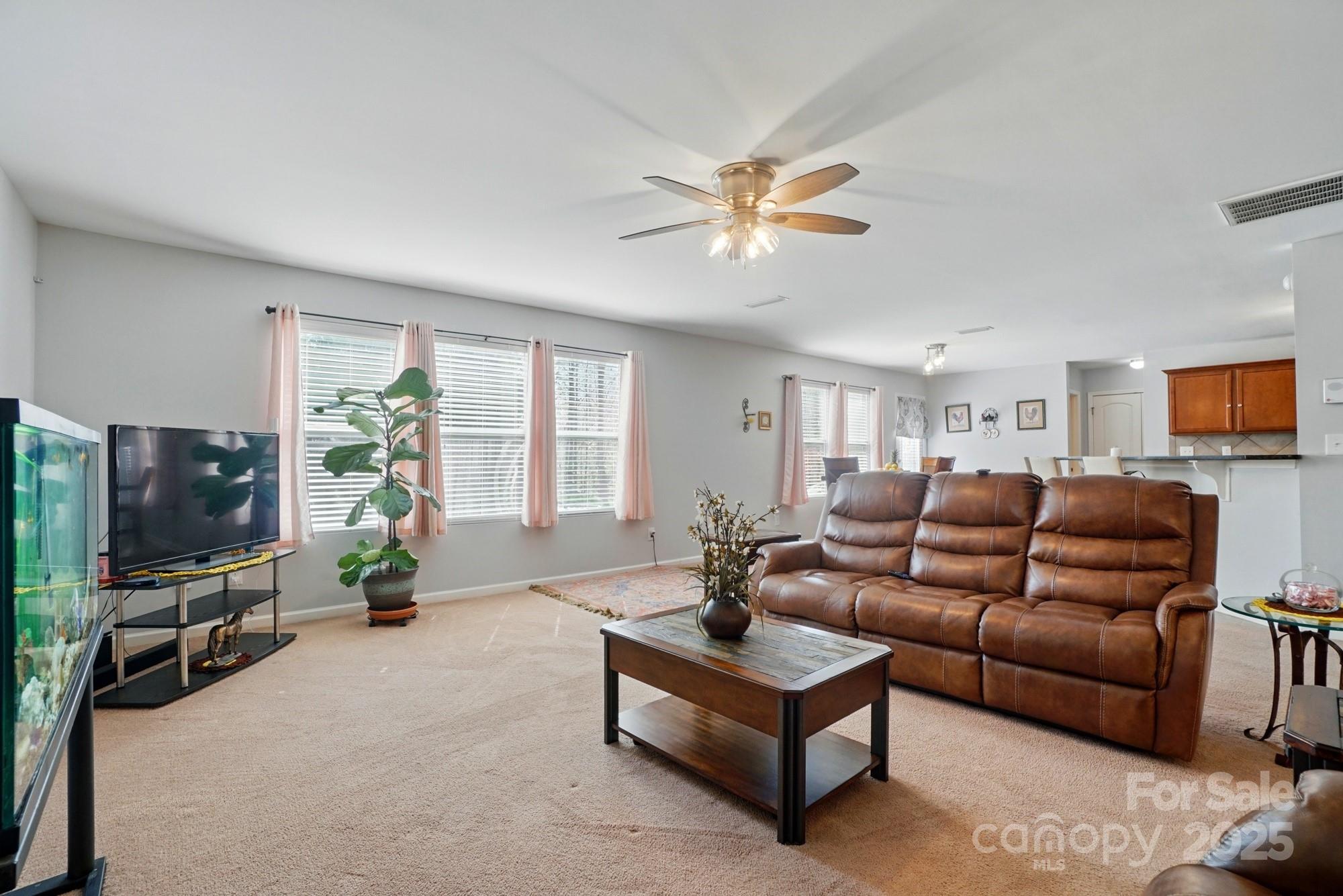 3272 Saddlebrook Drive Midland, NC 28107 - Photo 12 of 44 a living room with furniture a ceiling fan and a flat screen tv