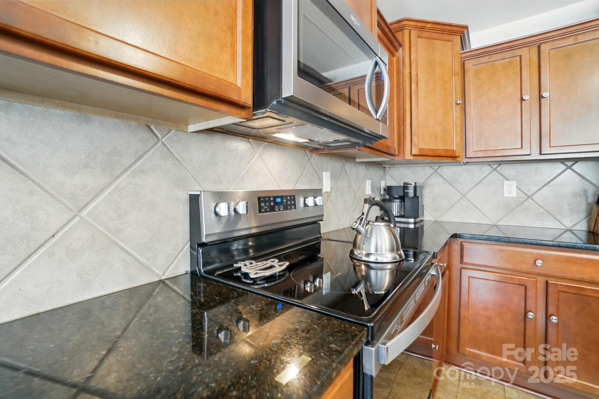 3272 Saddlebrook Drive Midland, NC 28107 - Photo 19 of 44 a kitchen with stainless steel appliances granite countertop a stove and cabinets