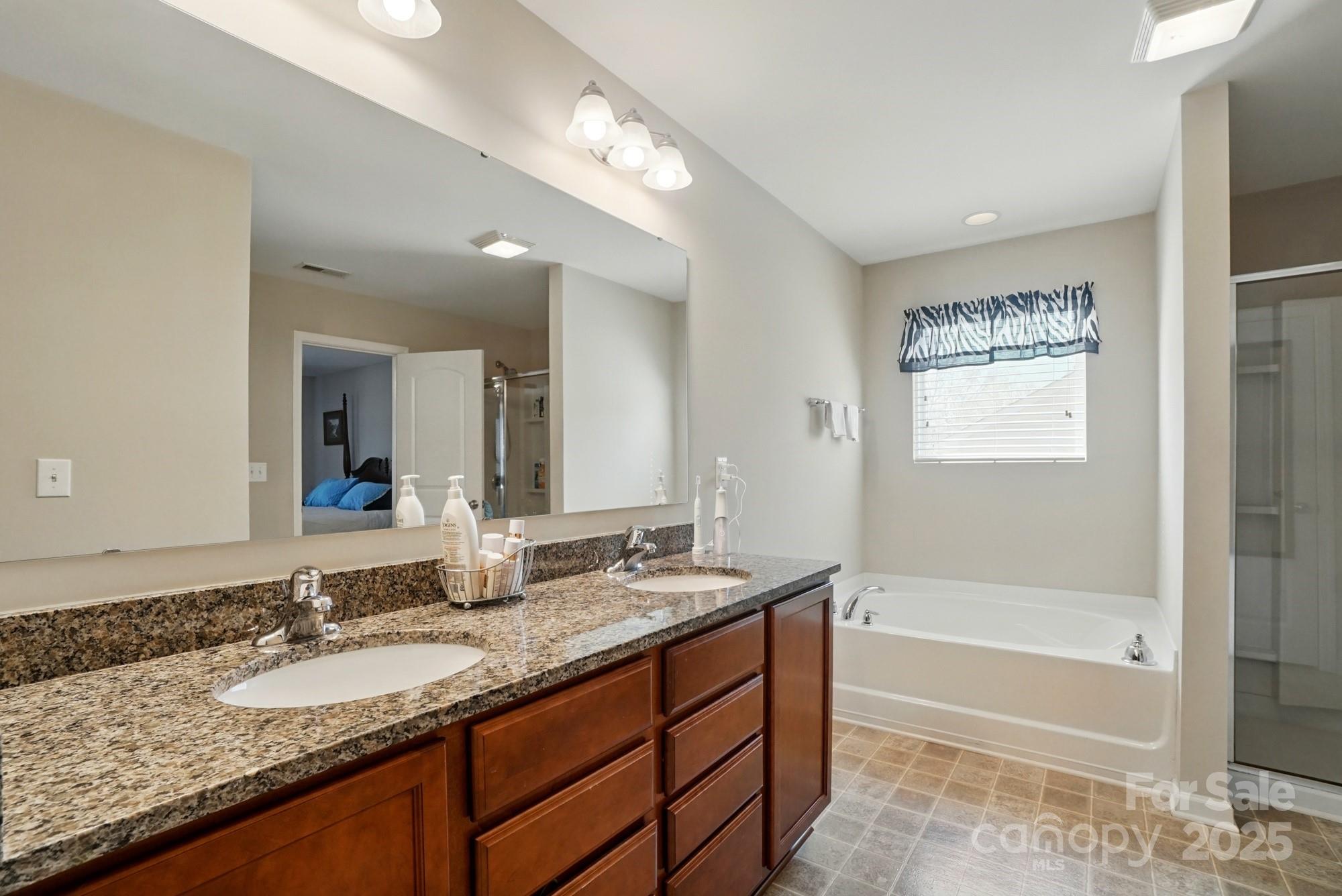 3272 Saddlebrook Drive Midland, NC 28107 - Photo 32 of 44 a bathroom with a granite countertop tub sink and mirror
