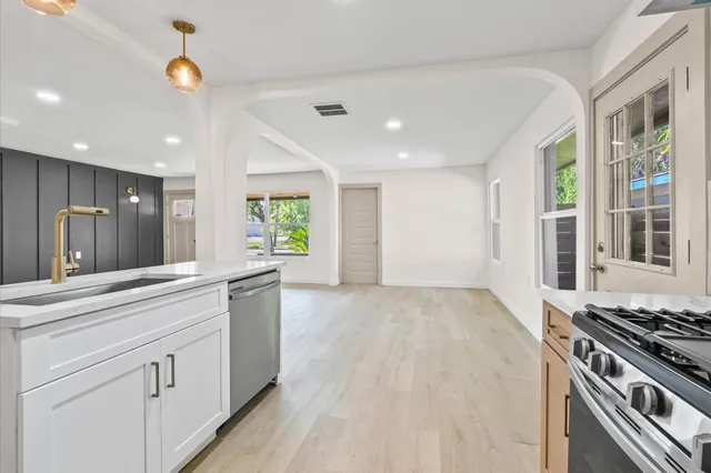 a kitchen with white cabinets and appliances