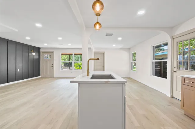 a kitchen with stainless steel appliances granite countertop a sink and a large window
