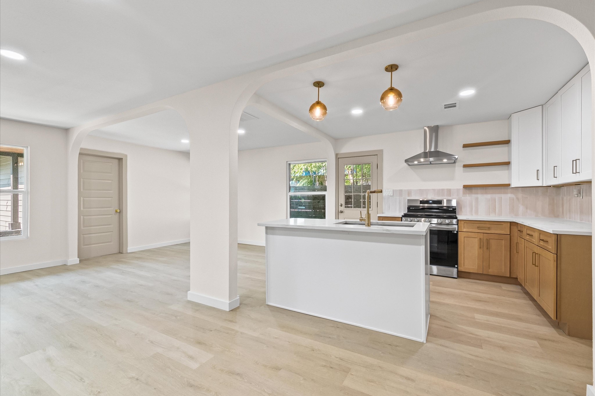 6527 Beekman Road Houston, TX 77021 - Photo 13 of 22 a kitchen with stainless steel appliances granite countertop a stove top oven a sink dishwasher and a refrigerator with wooden floor