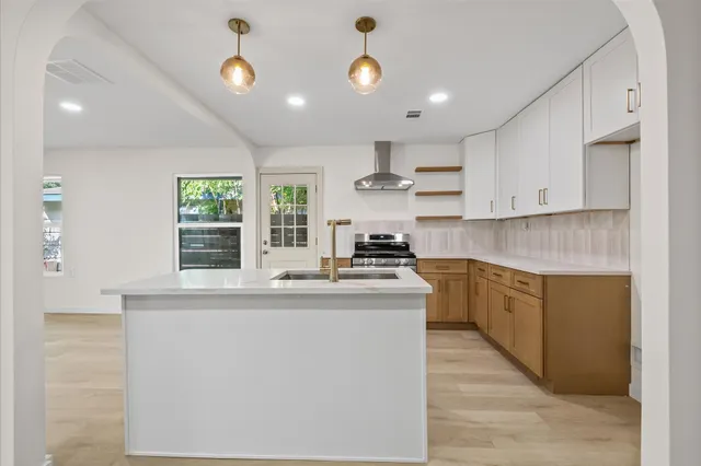 a kitchen with stainless steel appliances granite countertop a sink and a stove