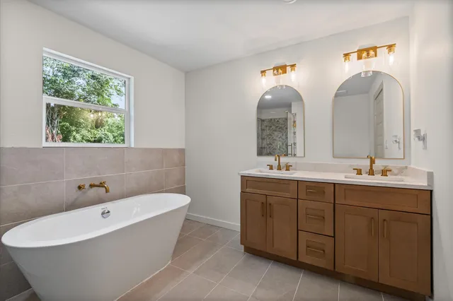 a bathroom with a tub sink and mirror