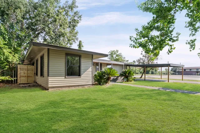 a view of a house with a yard and sitting area