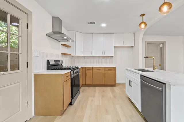 a kitchen with stainless steel appliances granite countertop a stove a sink and a refrigerator