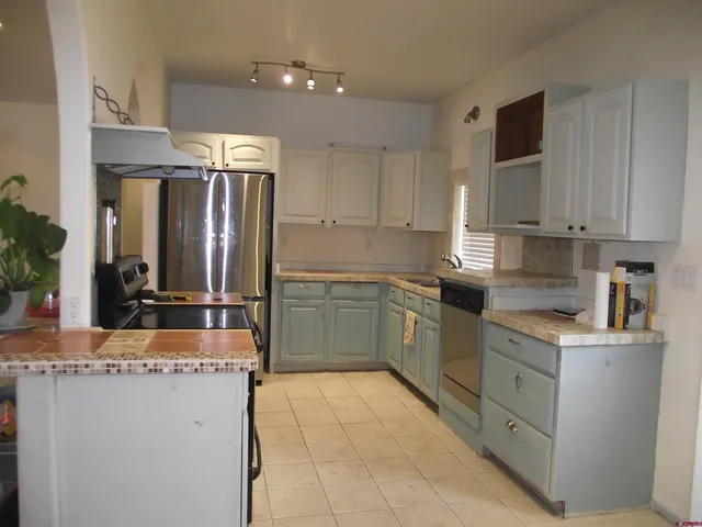 a kitchen with stainless steel appliances granite countertop a refrigerator and a stove top oven