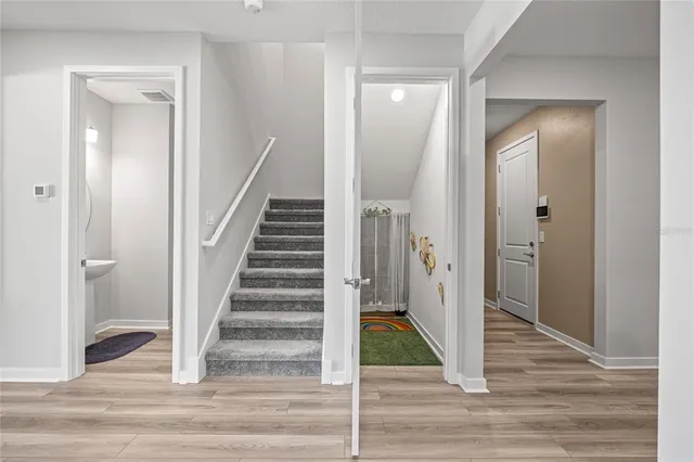 a view of a hallway with wooden floor and entryway