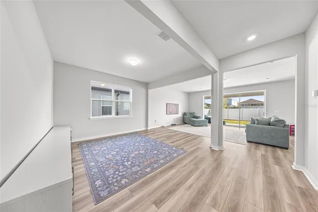 a large bedroom with a bed and wooden floor