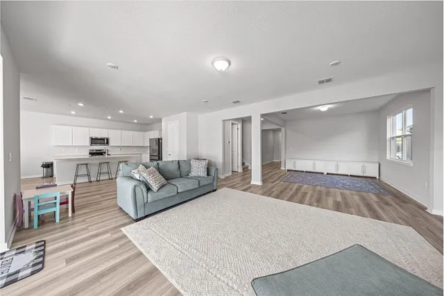 a living room with furniture and a wooden floor