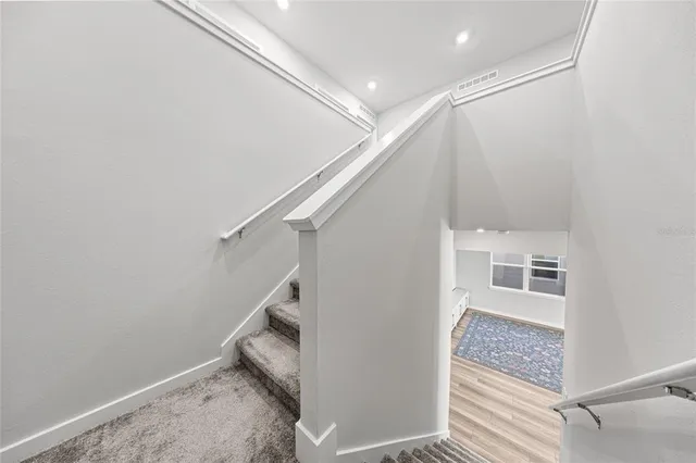a view of a hallway with kitchen and white walls