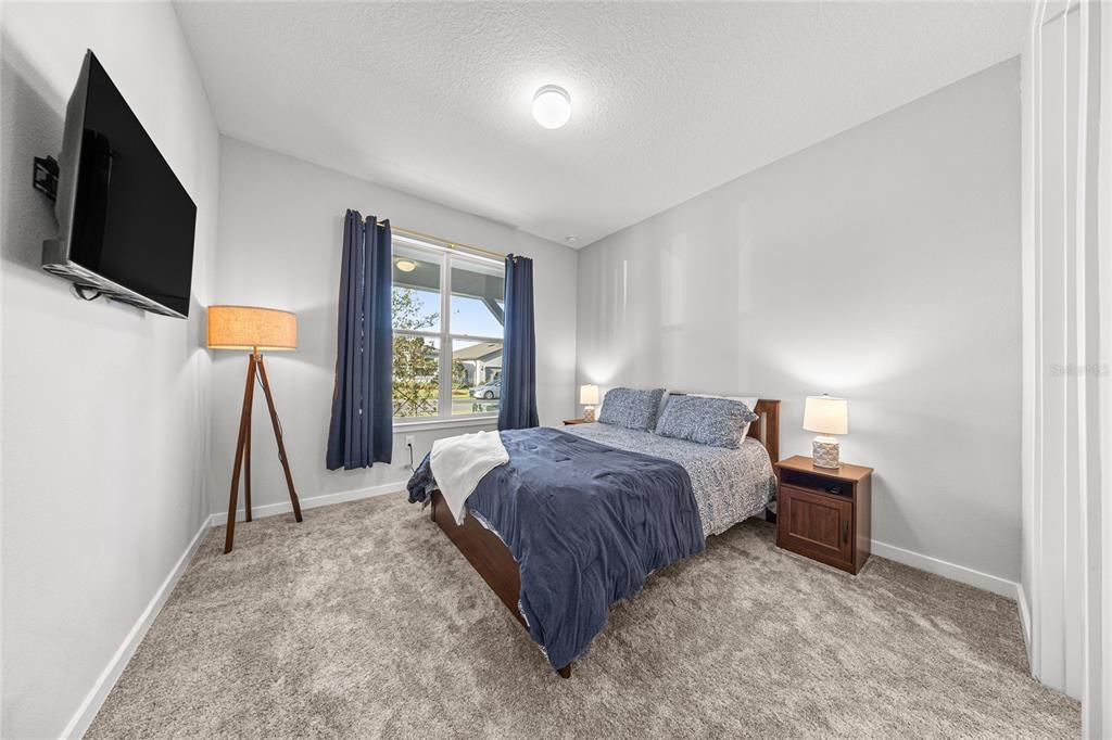 4472 Southwest 84th St Road Ocala, FL 34476 - Photo 8 of 50 a spacious bedroom with a bed and a flat tv screen on a dresser