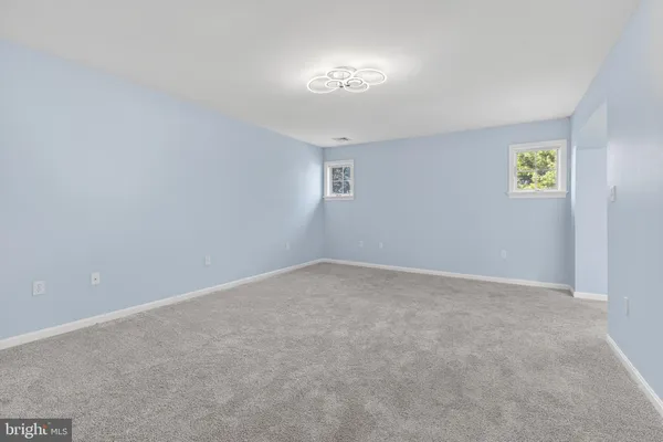 an empty room with an entryway and fan