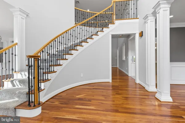 a view of staircase with wooden floor and white walls
