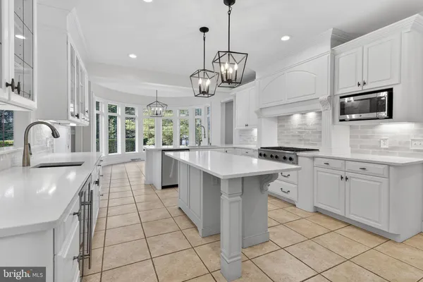 a kitchen with stainless steel appliances granite countertop a sink a stove top oven a counter space and cabinets