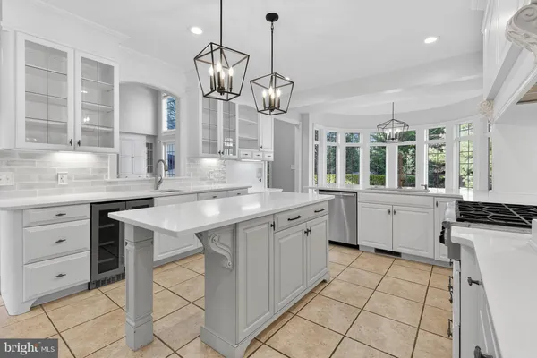 a kitchen with cabinets stainless steel appliances and a chandelier