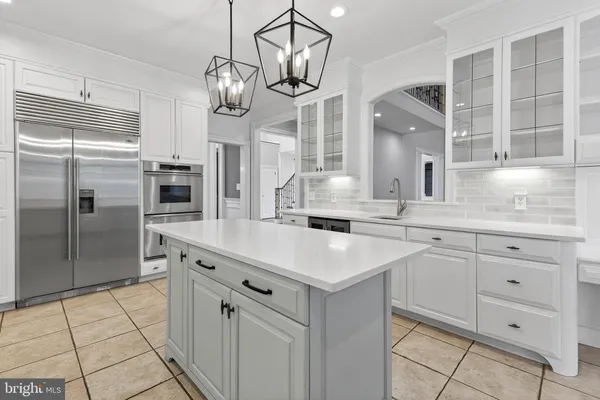 a large kitchen with kitchen island a sink appliances and cabinets