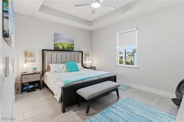 a bedroom with a bed a chandelier and a window