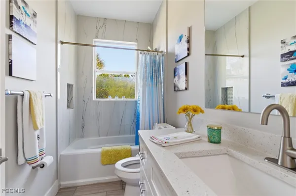 a bathroom with a granite countertop toilet sink and bathtub