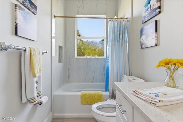 a bathroom with a bathtub sink vanity mirror and toilet