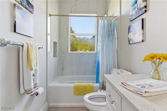 a bathroom with a bathtub sink vanity mirror and toilet