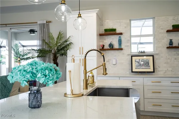 a picture of a kitchen with a window and flower pot