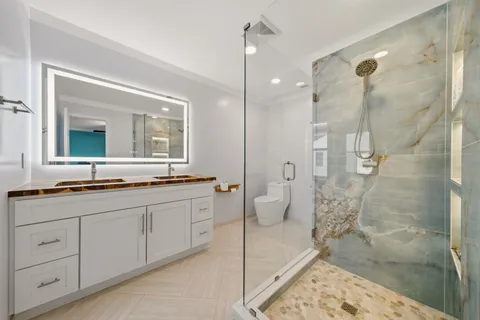 a spacious bathroom with a granite countertop sink mirror and a shower