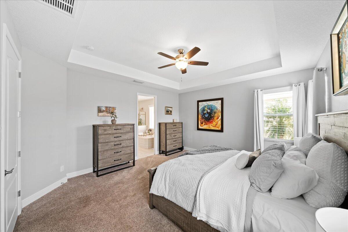 3447 Caviston Way Melbourne, FL 32940 - Photo 15 of 57 a bedroom with a bed and a chandelier