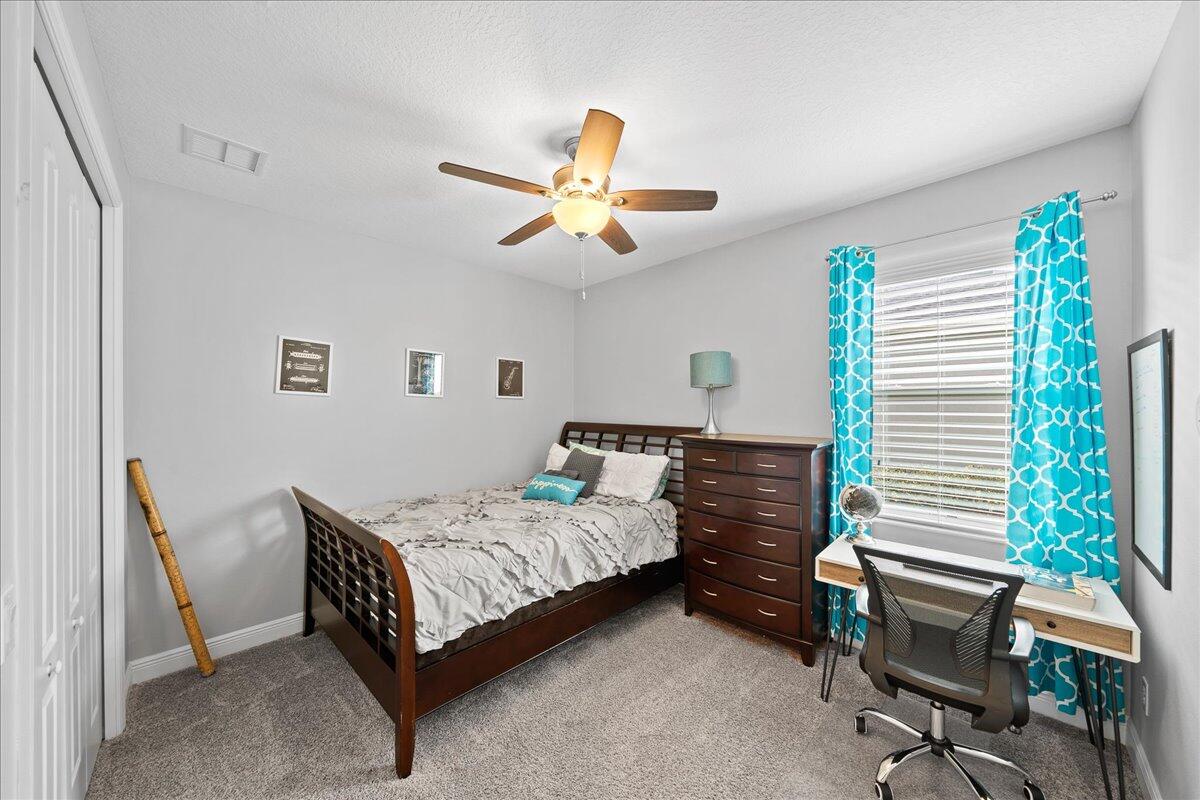 3447 Caviston Way Melbourne, FL 32940 - Photo 19 of 57 a bedroom with a bed and a chandelier