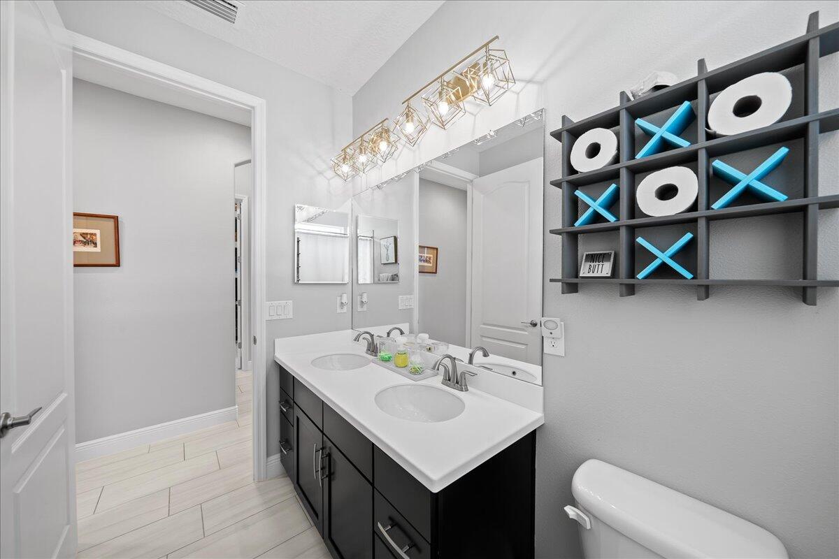 3447 Caviston Way Melbourne, FL 32940 - Photo 21 of 57 a bathroom with a sink mirror vanity and toilet