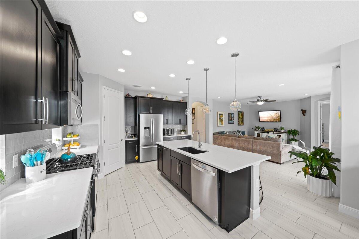 3447 Caviston Way Melbourne, FL 32940 - Photo 7 of 57 a kitchen with stainless steel appliances granite countertop a sink counter space and a stove