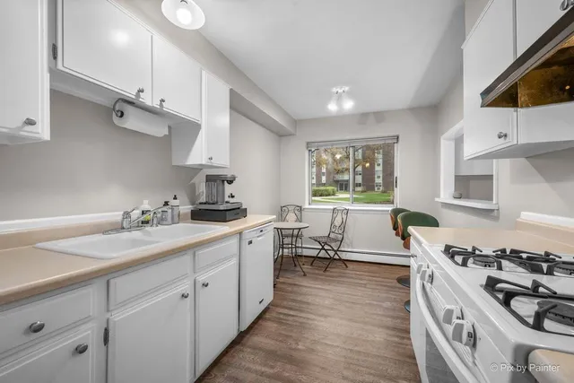 a kitchen with stove a sink and cabinets