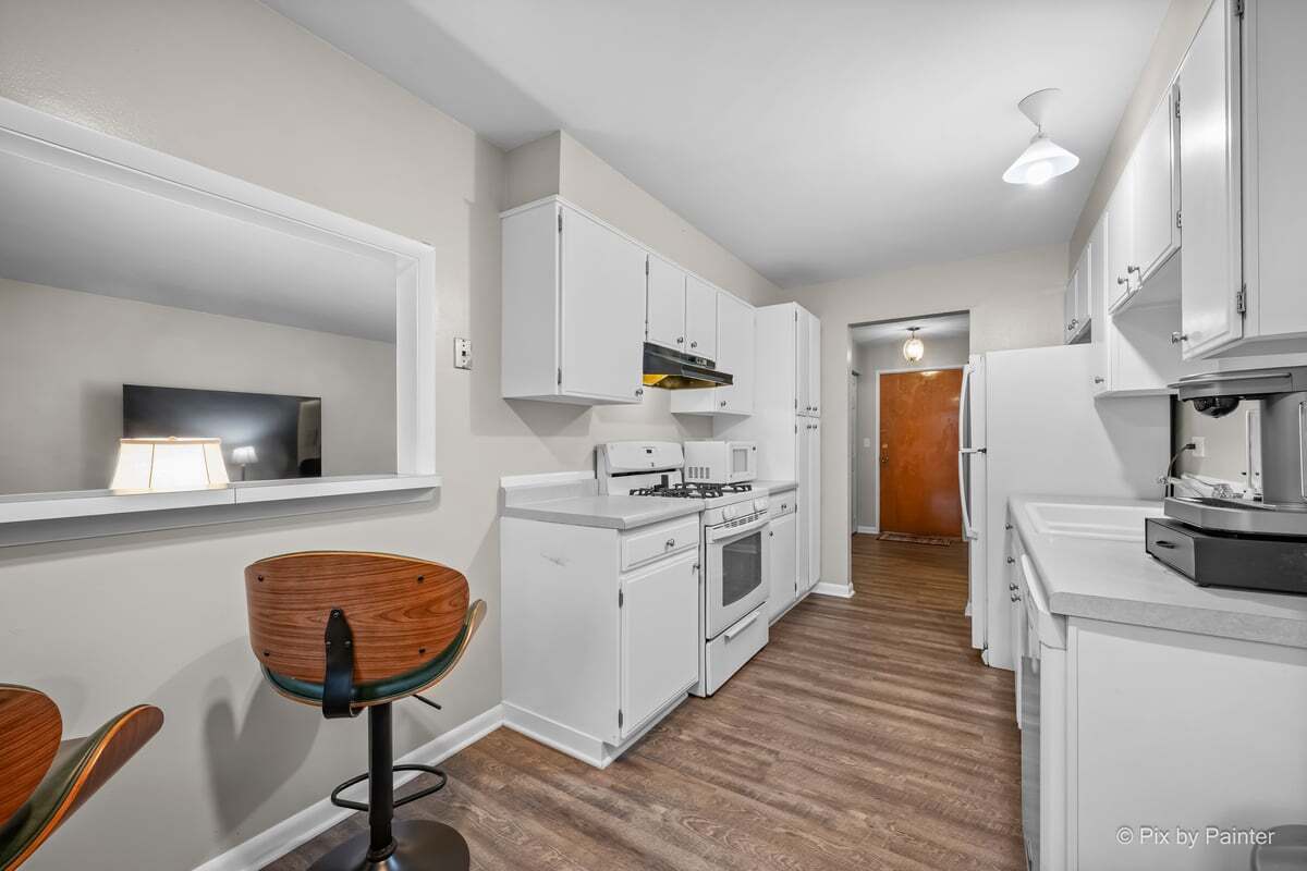 1311 South Finley Road, Unit 104 Lombard, IL 60148 - Photo 6 of 15 a kitchen with stainless steel appliances granite countertop a stove a sink dishwasher and a refrigerator with wooden floor