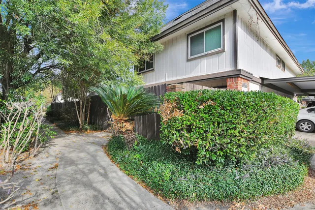 a front view of a house with plants