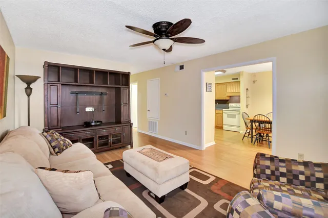 a dining room with furniture potted plants and wooden floor