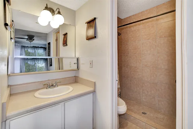a bathroom with a granite countertop toilet sink and mirror
