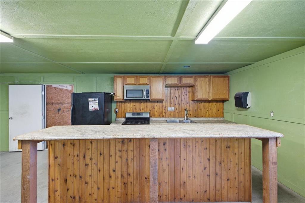 1341 Hildreth Pool Road Bowie, TX 76230 - Photo 28 of 40 a kitchen with cabinets and wooden floor