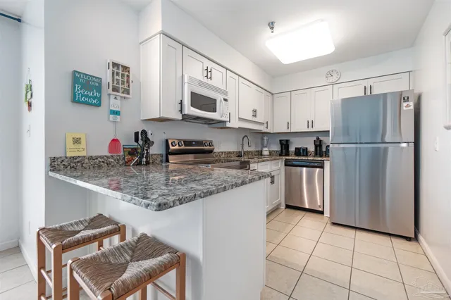 a kitchen with stainless steel appliances granite countertop a refrigerator sink stove microwave and cabinets